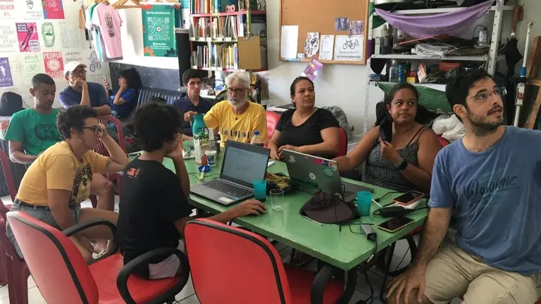 A group of individuals sitting around a table, engrossed in their work on laptops.