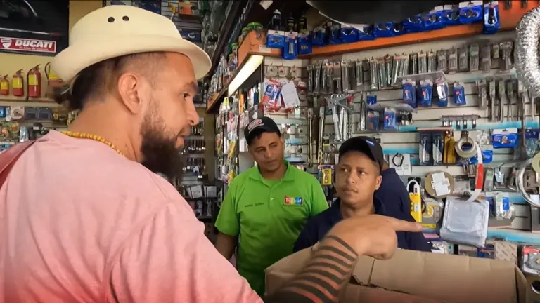 A man wearing a hat is talking to a man in a hardware store.