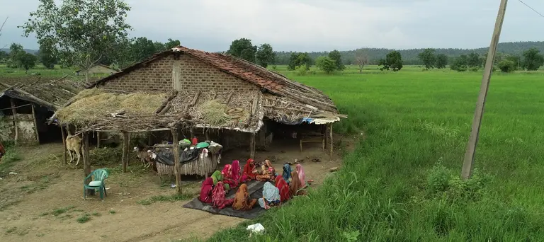 A group of women gathering together next to a field.