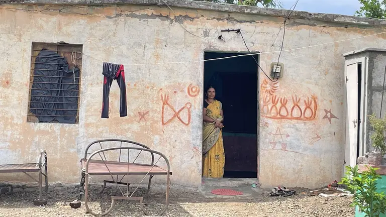 A woman stands in a doorway.