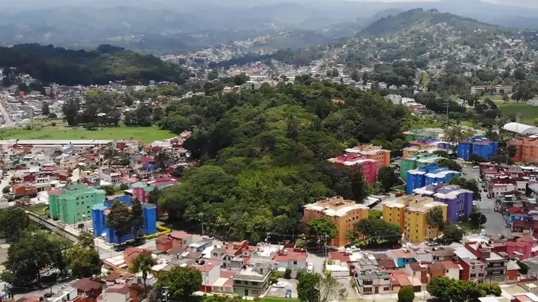 Distance view of an urban landscape with mountain in the background.