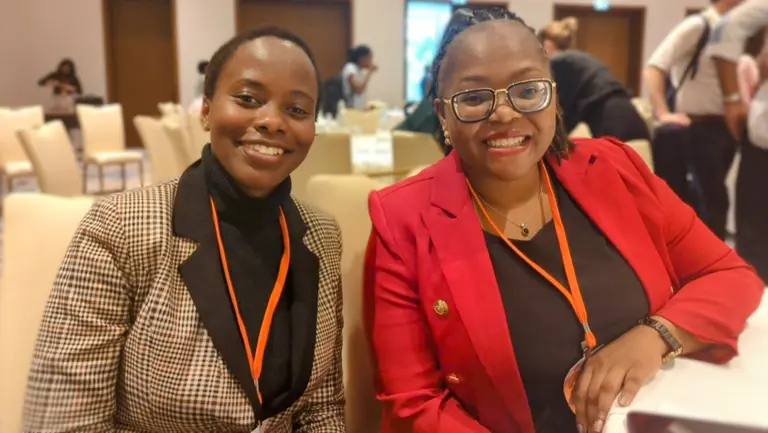 Two women smiling at the camera.