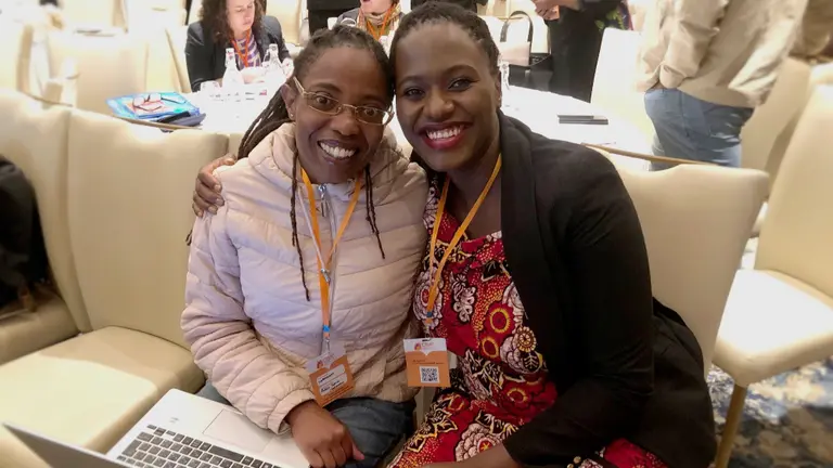 Two women smiling at the camera.