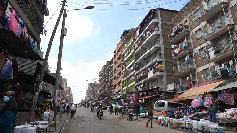 Street scene with multistorey flats and market stalls.