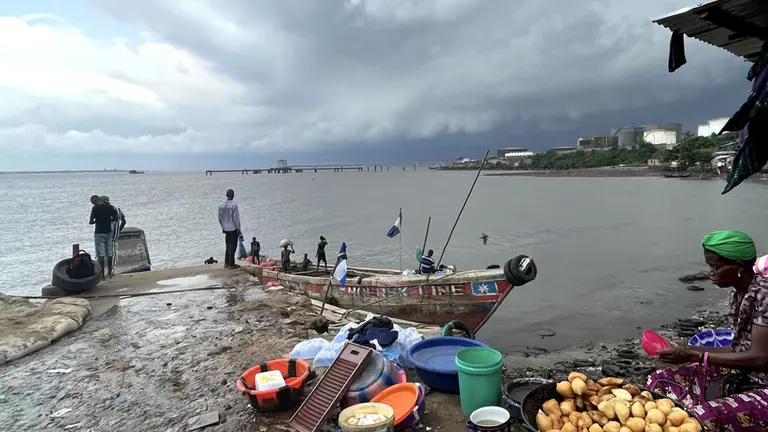 A boat on a jetty, with food supplies on the ground.