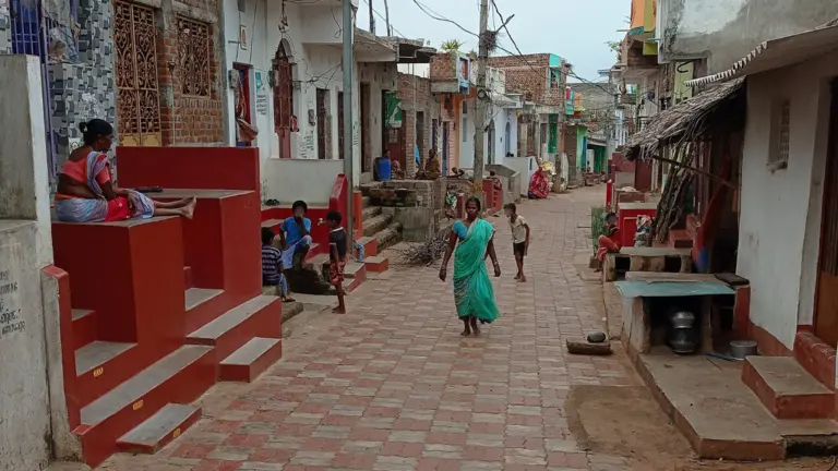 Image showing the fishing community slum of Sai Baba Sahi after the construction, with a main street paved with stones, houses and shops. 