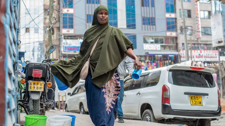 Woman walking down the street in Nairobi, selling tea.