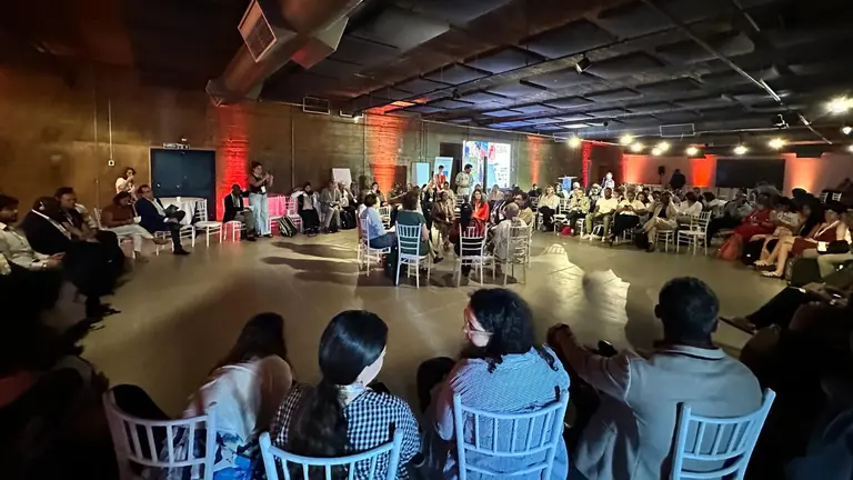 Interactive exercise called 'fish bowl' during a session at CBA19. A small group of people sit in a circle in the middle of a room and discuss, while the rest of the audience sits around them, at a distance.