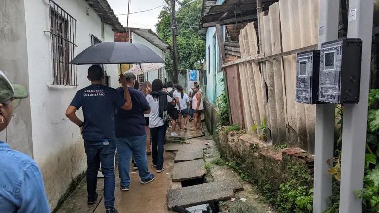 Group of CBA19 participants walking the streets of Recife, showing river contamination.