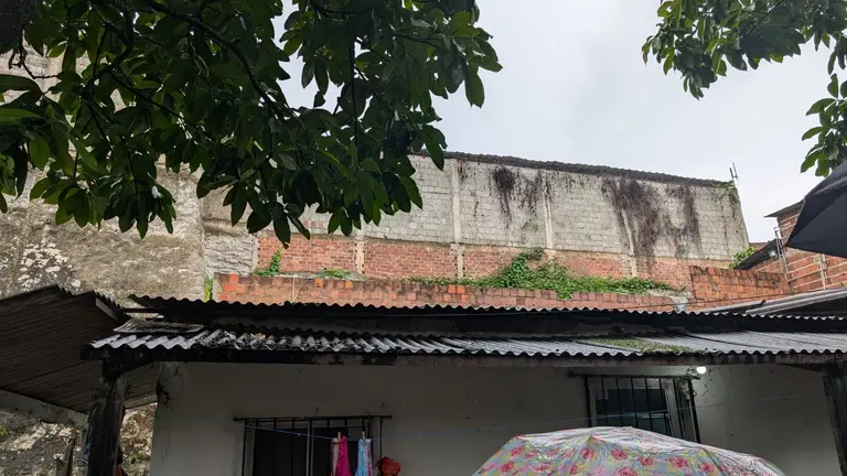 Wall built alongside the community by the bus company, who continues to dump oil in the community.