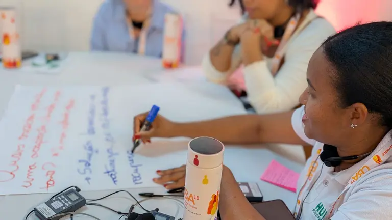 Workshop participants discussing and writing ideas down on flipchart paper.