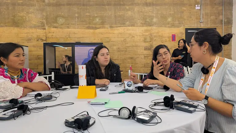 Group of CBA19 participants sitting around a table, talking and gesticulating.