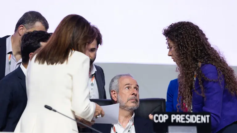 People gathered around the COP30 president, deliberating.