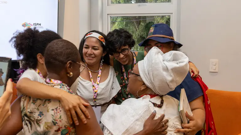 Panel members from the Global South hugging after talk.