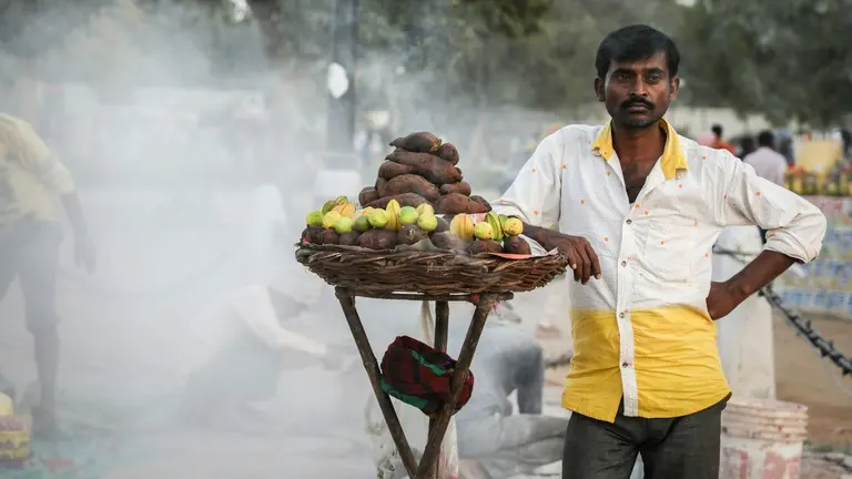 Man selling fruit and vegetable on the busy streets in India.