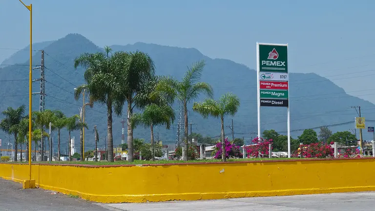 A petrol station behind a bright yellow wall.