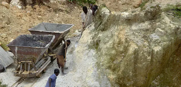 Small-scale miners dig soil mining for tin in Rwanda. 