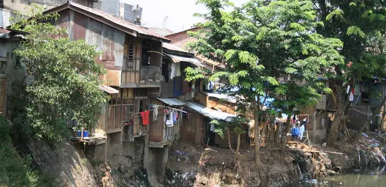 Houses teeter on the edge of a river in Indonesia.