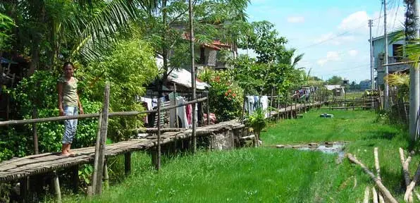 A woman walks along a bamboo walkway in Iloilo, Philippines.