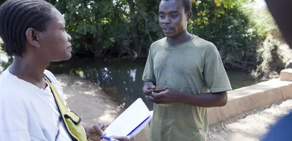 A researcher speaks to a cotton farmer in Mozambique. 