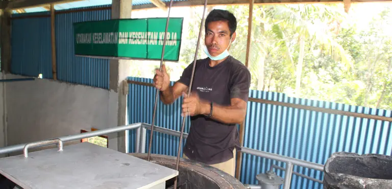 A man stands behind an electricity generator