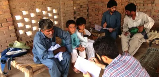 Researchers talk to villagers in Sheikhuwal village in rural Pakistan