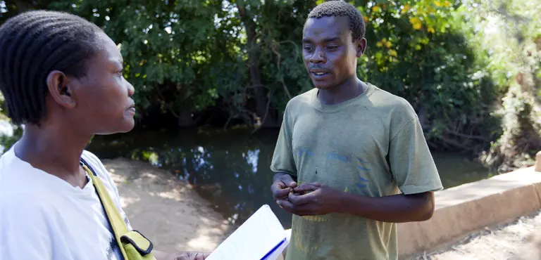 A researcher talking with a cotton farmer in Mozambique. Communicating our findings to a wide range of key audiences is central to our work (Photo: Mike Goldwater)