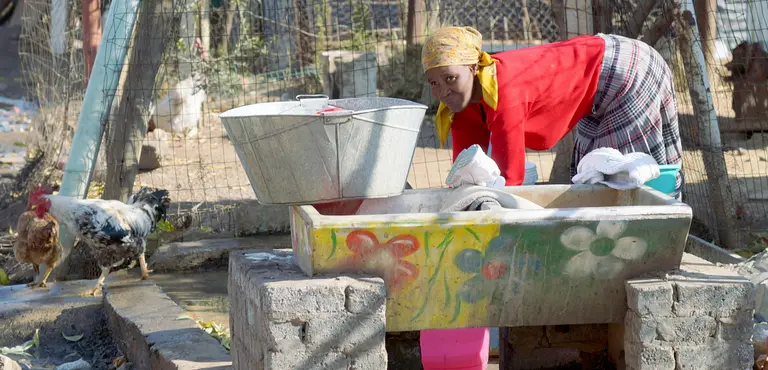 Woman using a public water tap in Kliptown, Soweto, Johannesburg, South Africa. Johannesburg uses 32 different indicators to assess progress towards its strategic goals. Indicators need to reflect the needs of marginalised and vulnerable groups (Photo: Ray Muzyka, Creative Commons via Flickr)