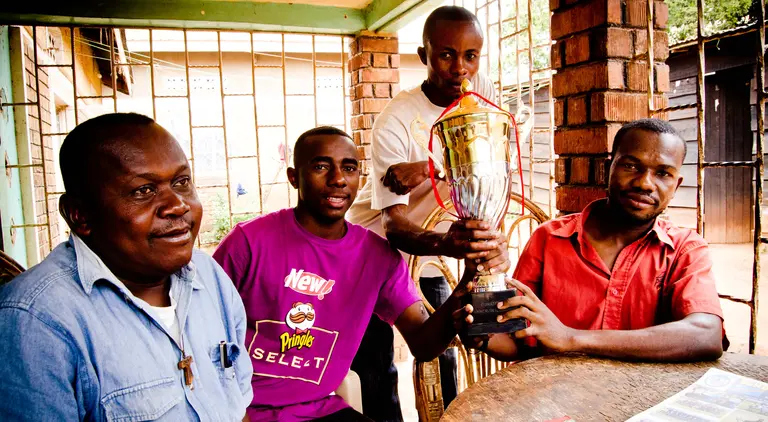 Congolese refugees proudly display the cup they won in a football tournament for youths from refugee communities in Kampala (Photo: Stephen Luke, Creative Commons via Flickr)