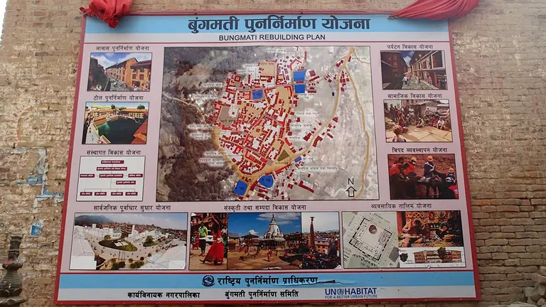 A poster of the Bungamati Action Plan, a co-production between the University of Leuven, UN-Habitat, the local relief committee, and local stakeholders, on the side of a building outlines rebuilding plans following the Nepal earthquake (Photo: Patrick Daly)