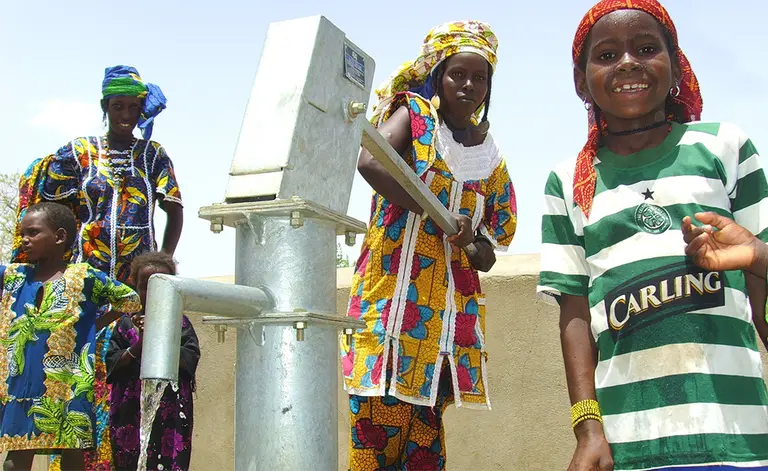 Children using water pump in Burkina Faso