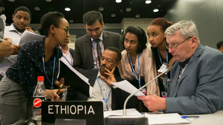 Delegates from the LDC Group, including chair Gebru Jember Endalew and IIED's Achala Abeysinghe discuss the revised APA text, Bonn, May 2017 (Photo: IISD/ENB/Kiara Worth)