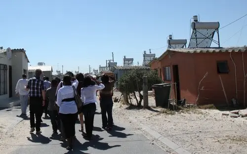 People visiting a village with solar panels