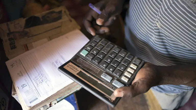 A merchant calculates costs in Geita District, Tanzania (Photo: Brian Sokol/Panos Pictures)