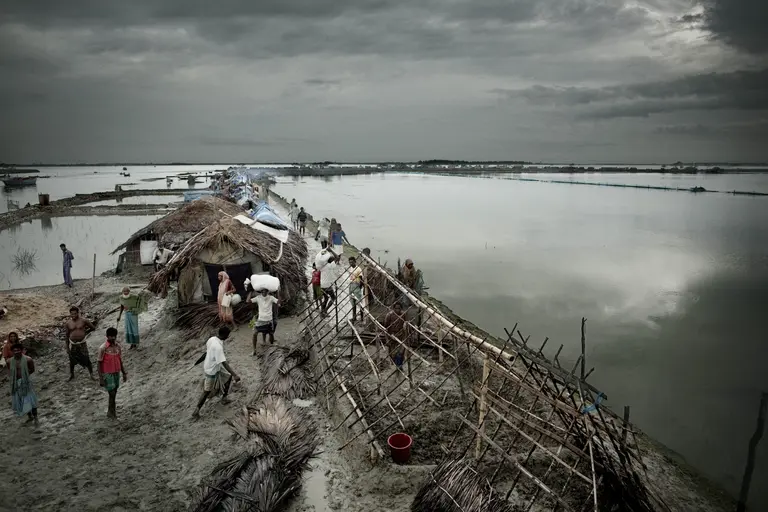 People build temporary shelters on the edge of the Bay of Bengal following a cyclone and flooding