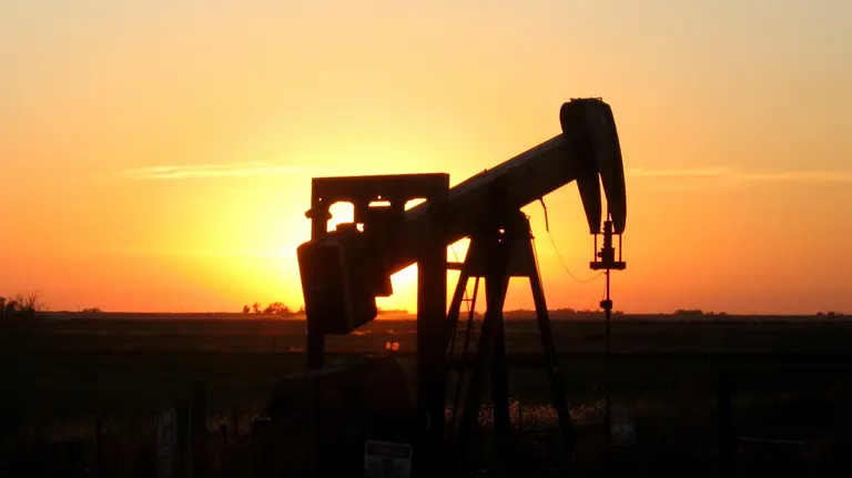 An oil rig silhouetted at sunset