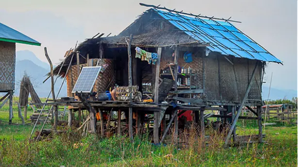 A solar panel outside a rural house on stilts 