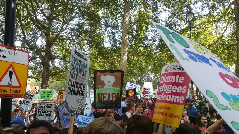 Protesters march and carry climate-related placards