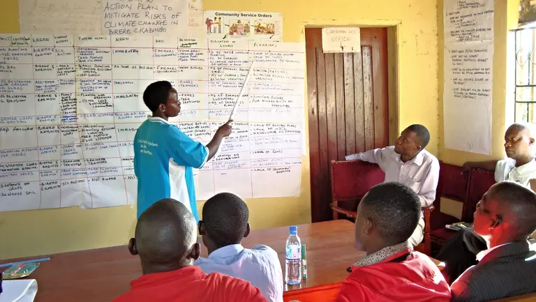A man pointing to a list on a flipchart
