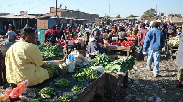 Busy market scene, showing traders with their vegetables
