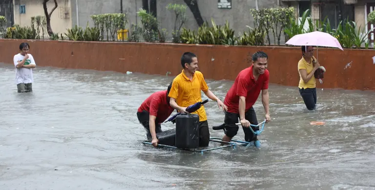 People walking down a flooded road