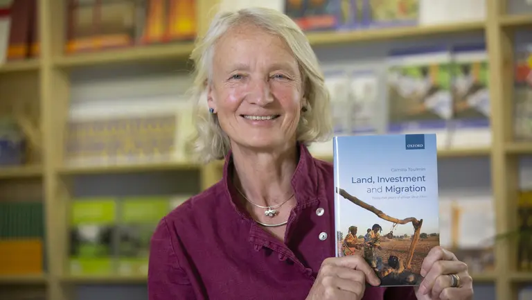 Camilla Toulmin holding her new book