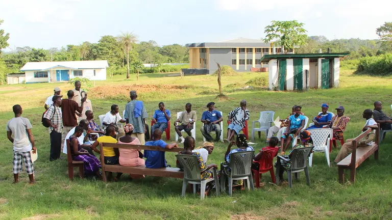 A large group of people sitting in a circle outdoors