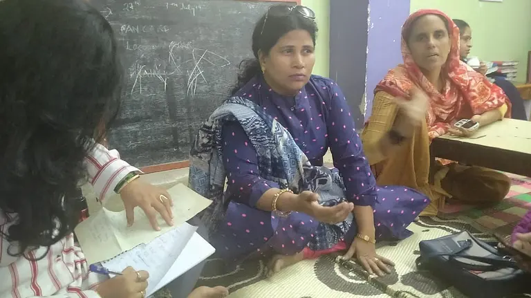 Three women sit on the floor for a meeting 