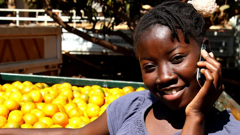 A woman holding a mobile phone and smiling