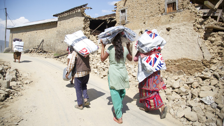 Women carrying emergency shelter kits