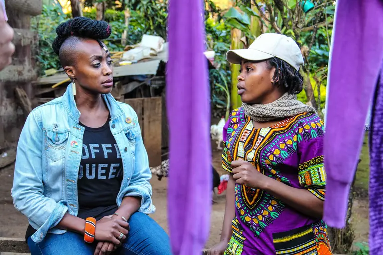 Two women sitting down and speaking to each other.