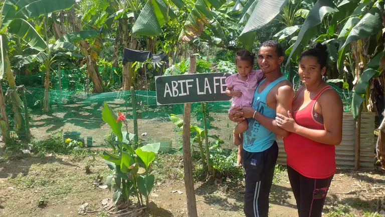A family standing in front of a smallholding.