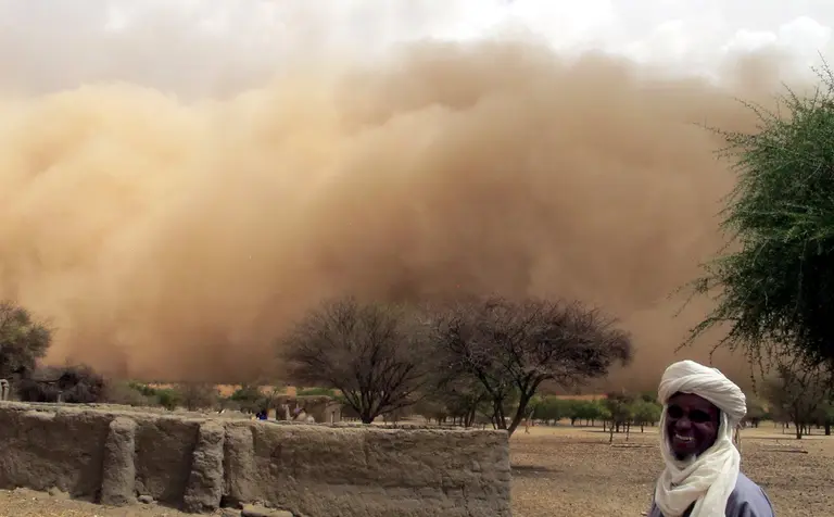 a man standing in front of a sandstorm