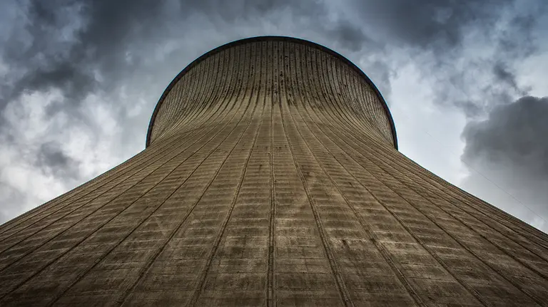 A cooling tower of a power station is framed against the sky